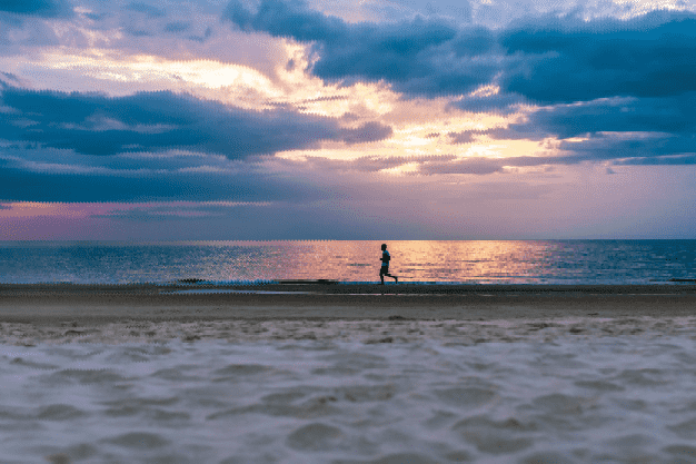 Persona corriendo al amanecer en la playa representando la bajada de precios en seguros de vida seguros de vida se abarataran